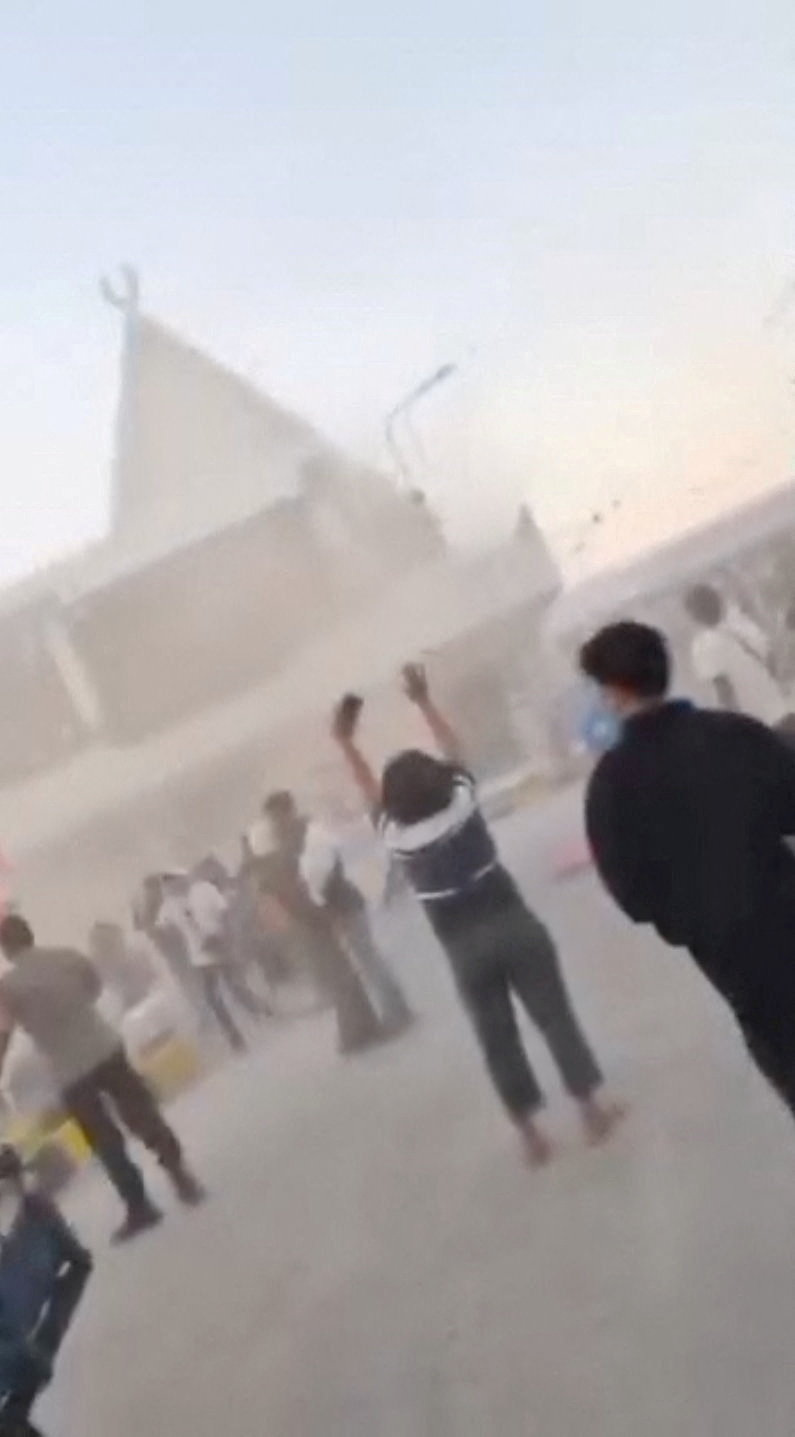 People react to a building collapse at Maumere port following an earthquake