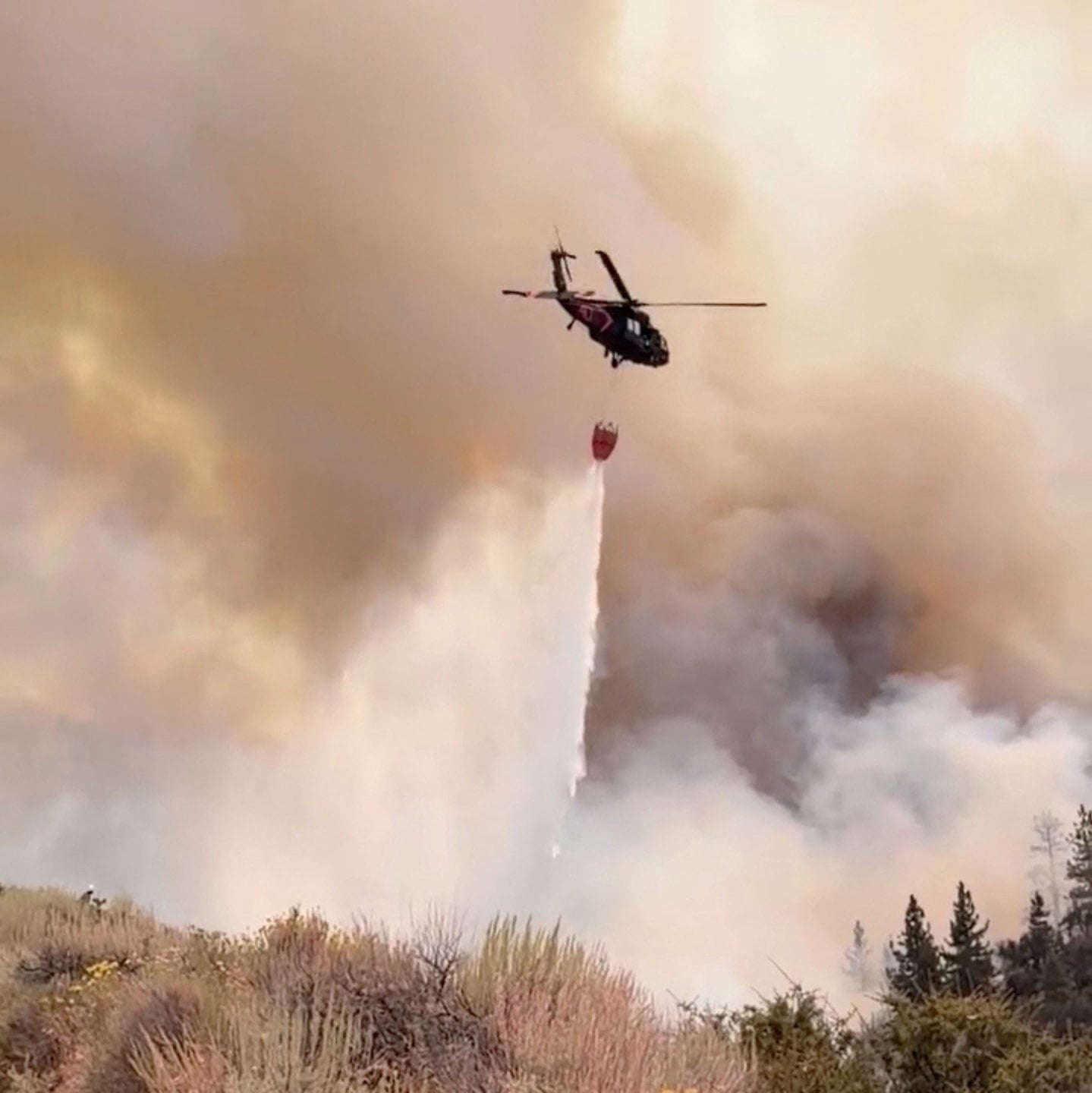 A Nevada National Guard helicopter drops water on the Hawk Fire in Reno