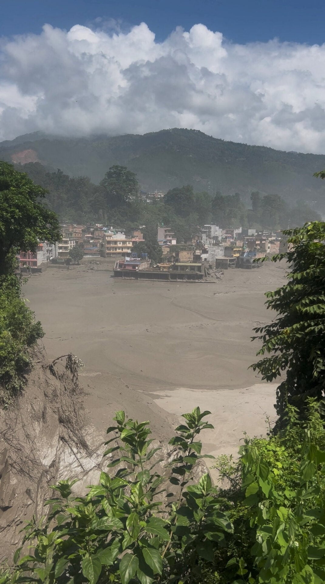 Partially submerged buildings along the riverbank due to a flash flood in Nuwakot district