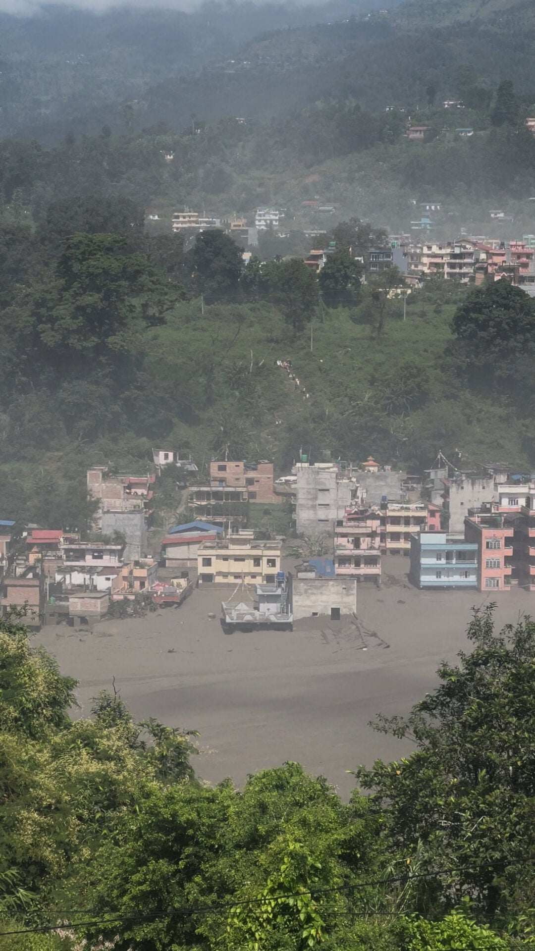 Partially submerged buildings along the riverbank due to a flash flood in Nuwakot district