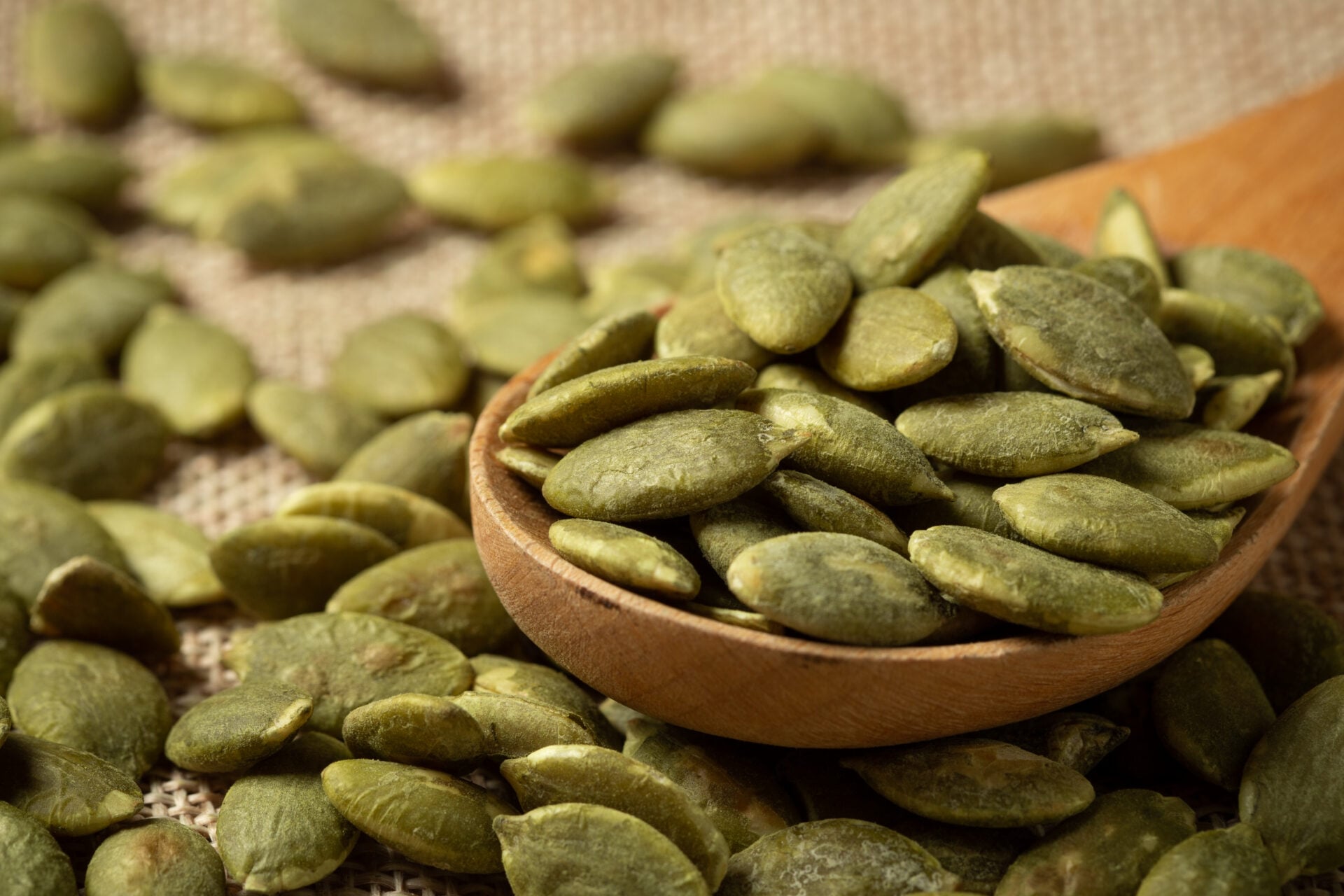 Macro green pumpkin seeds texture background.