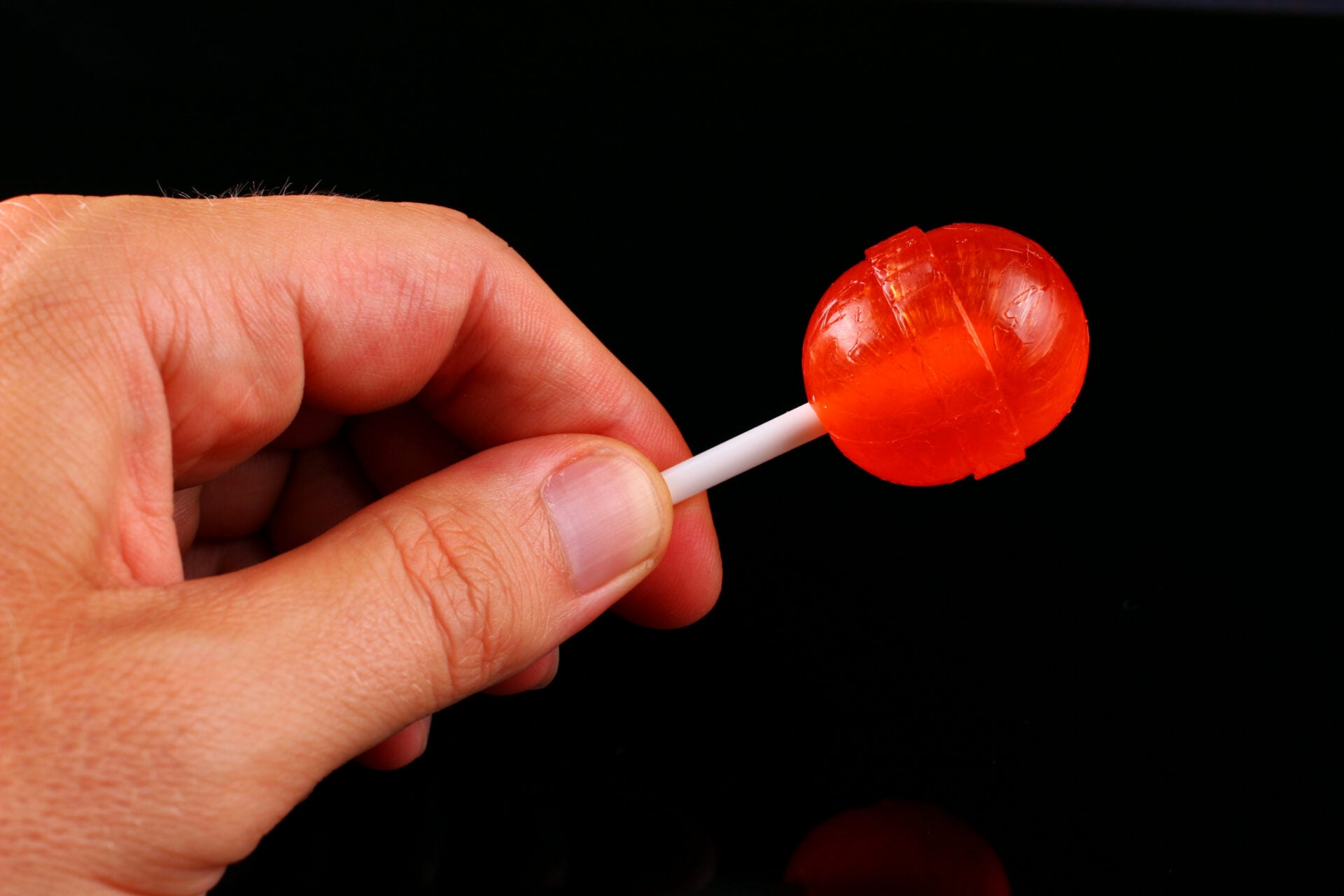 Caramel candy on a stick in hands