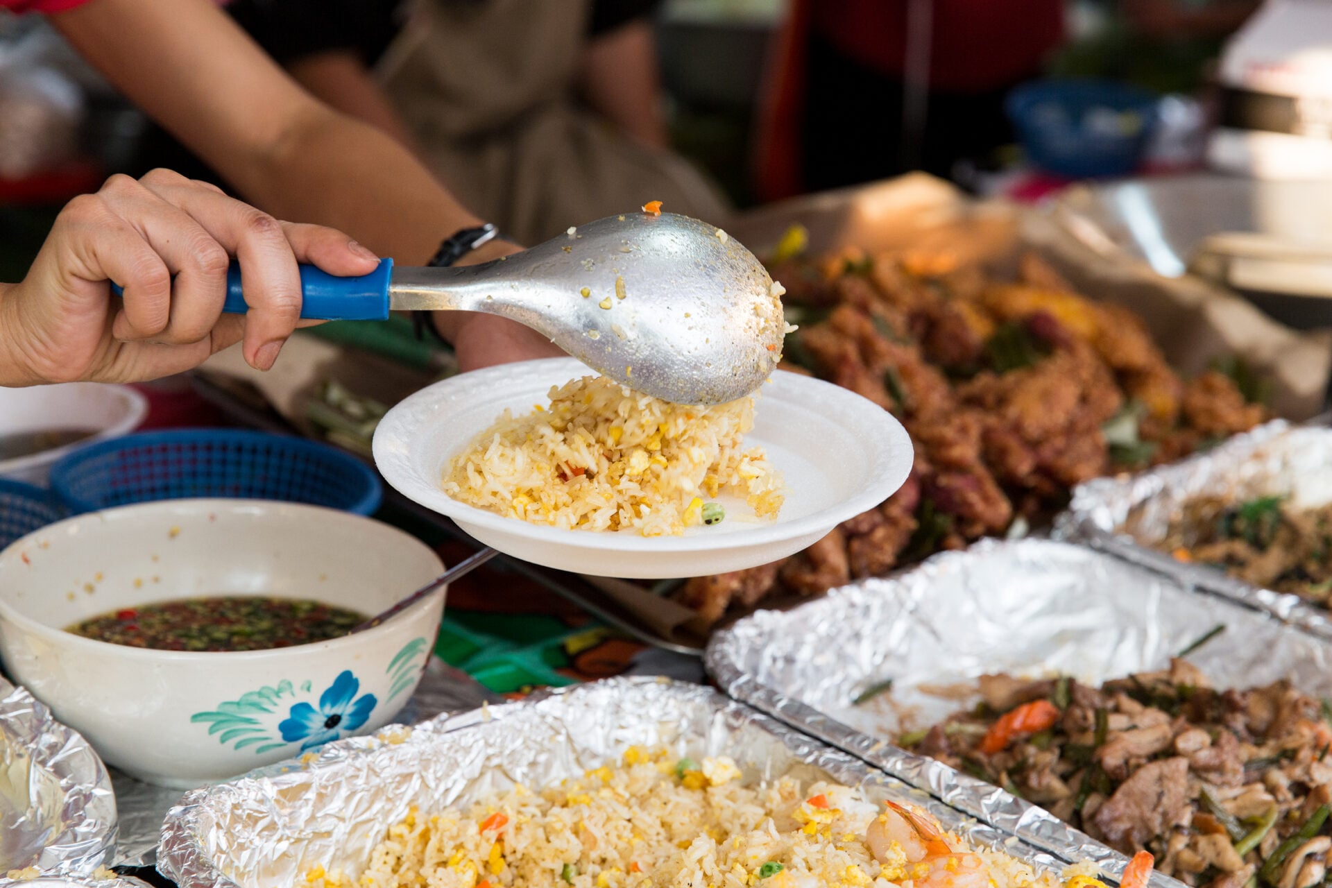 close up of hands with wok at street market