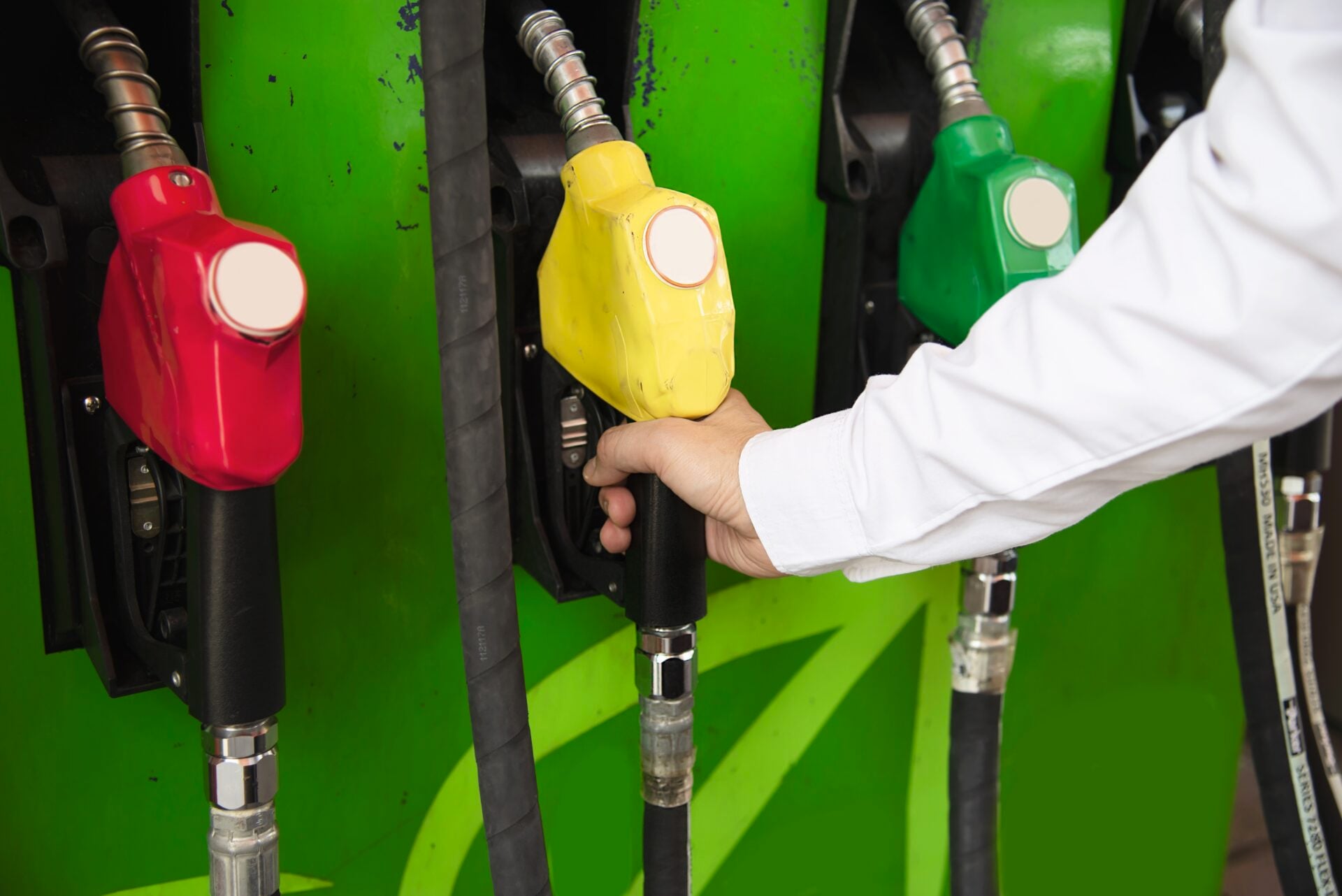 Man putting gasoline fuel into his car in a pump gas station Man putting gasoline fuel into his car in a pump gas station