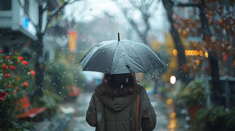 woman-is-walking-down-street-rain-with-umbrella