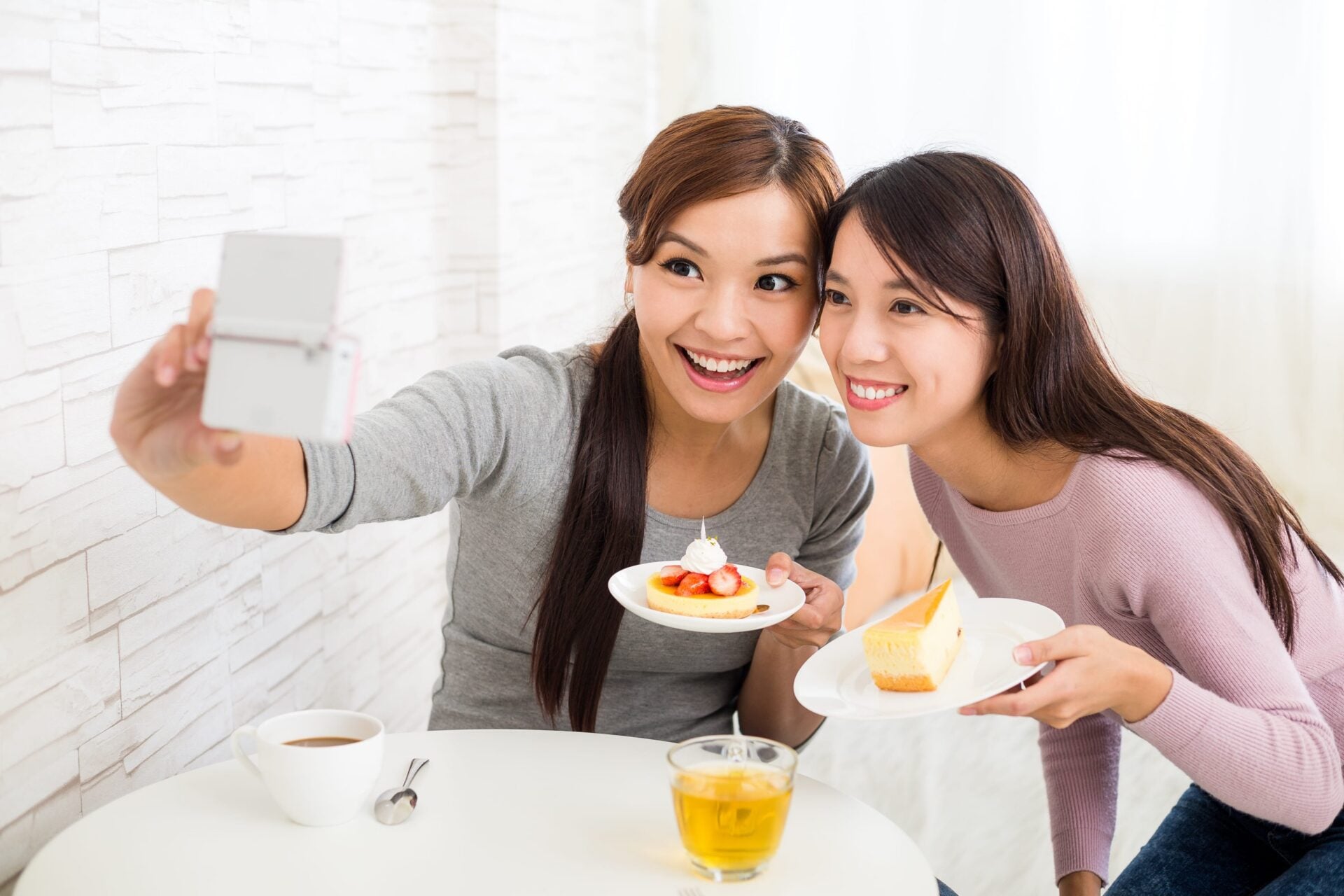 Young women taking photo in cafe