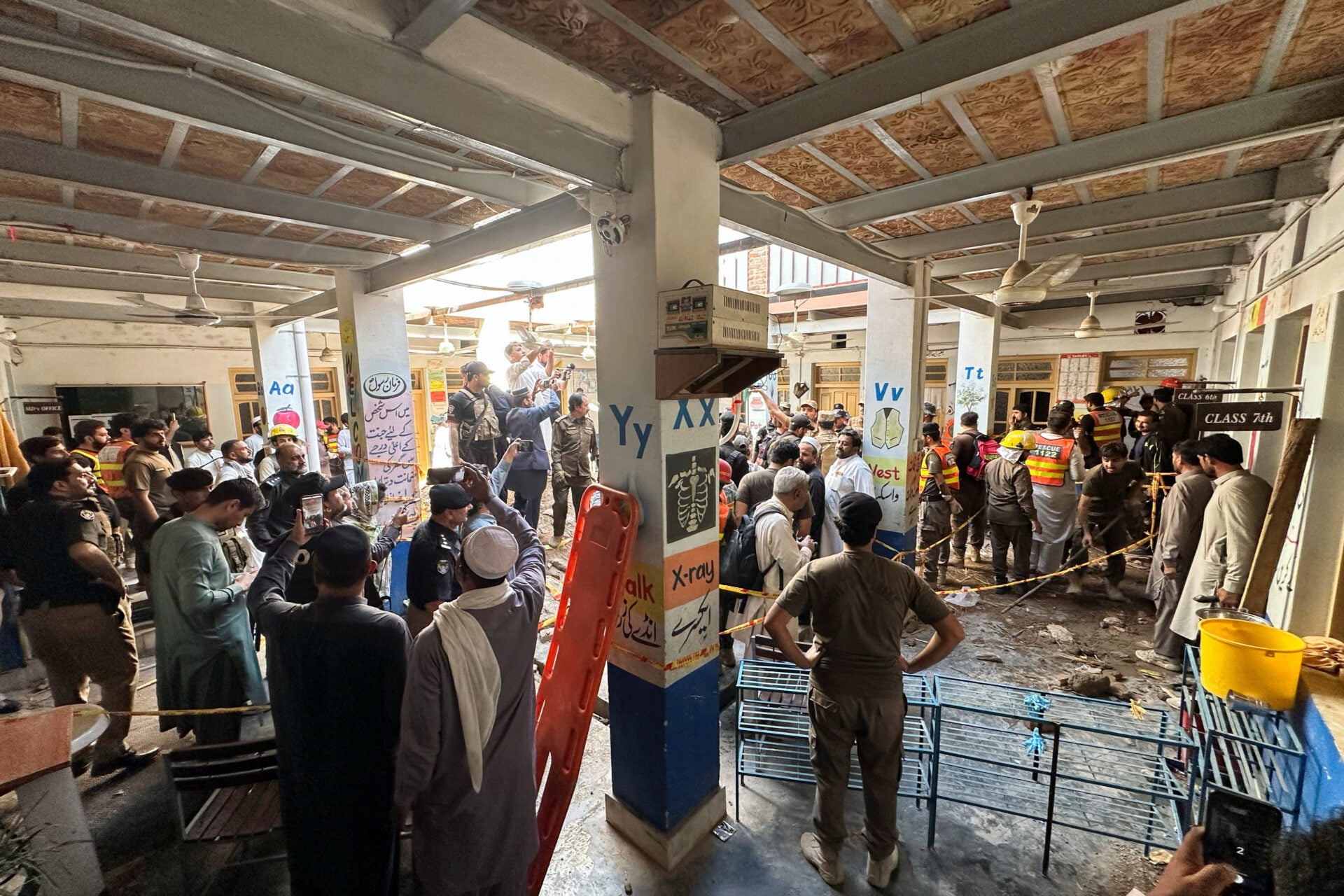 Rescue workers and residents gather after a school roof collapse in Peshawar