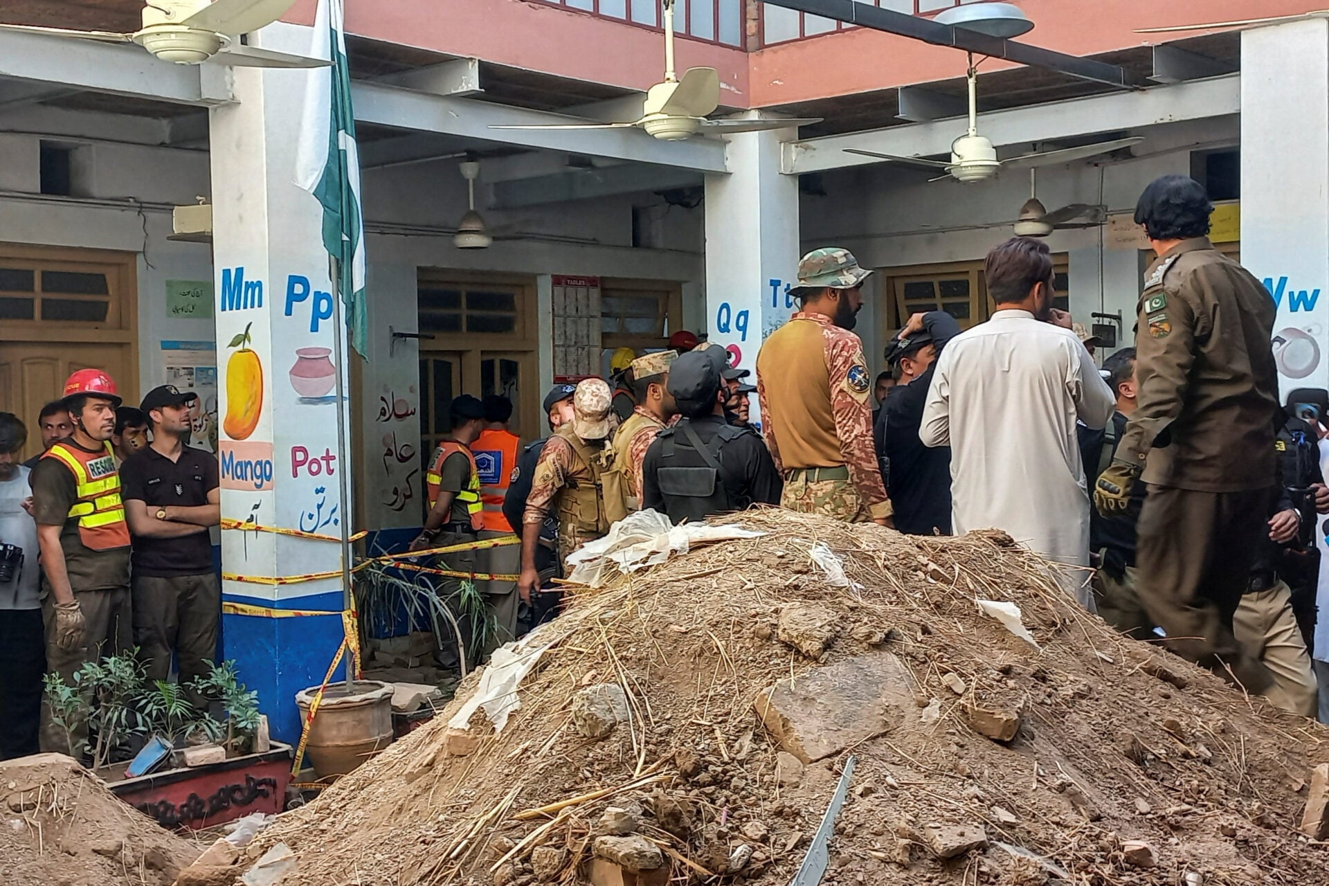Army soldiers and rescue workers gather after a school roof collapse in Peshawar